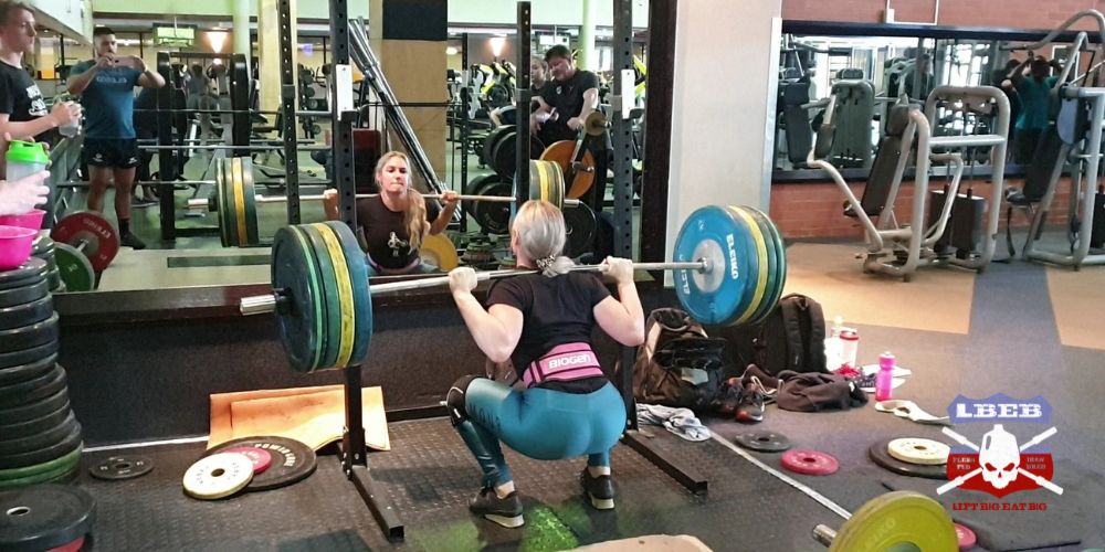 Mona Pretorius de Lacey high bar back squatting 110 kg in weightlifting shoes with a belt 